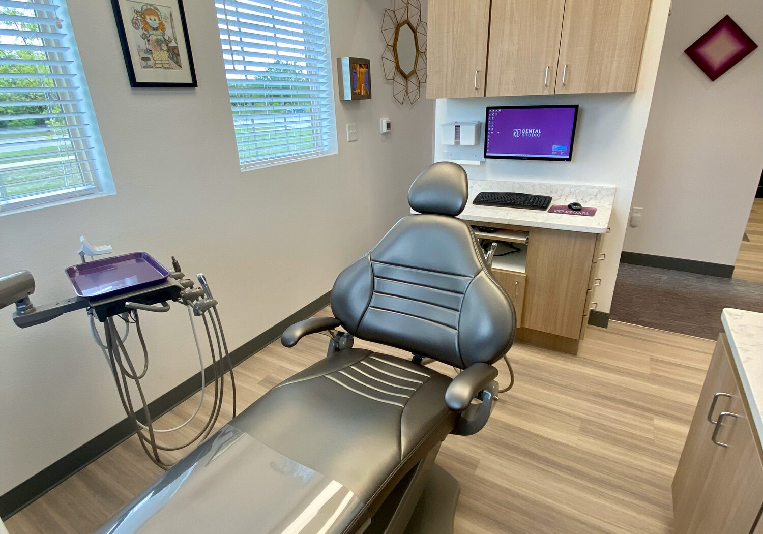 **Alt Text:** Private dental treatment room with exam chair, delivery system, and built-in cabinetry at KL Dental Studio.